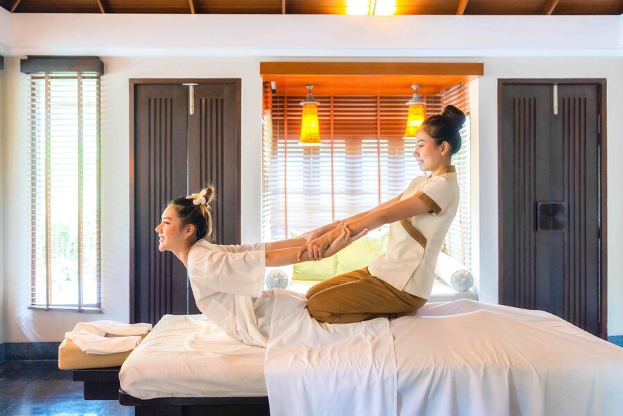 Thérapeute pratiquant un massage thaïlandais traditionnel dans un spa à Phuket