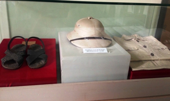 Casque colonial et sandales exposés en vitrine au musée du textile de Nam Định