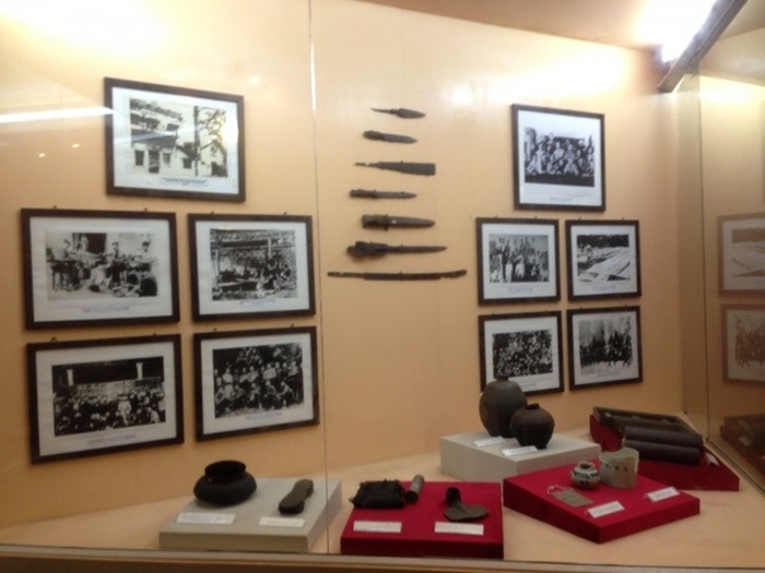 Photos d'archives encadrées et outils anciens exposés au musée du textile