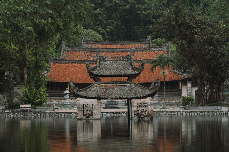 Pavillon sur l'eau aux toits de tuiles devant les bâtiments de la pagode du Maître