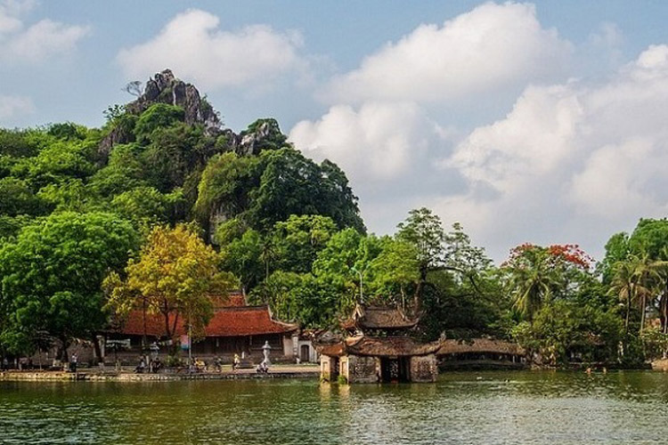 Pagode et pavillon au bord du lac au pied de la montagne Sài Sơn couverte de forêt