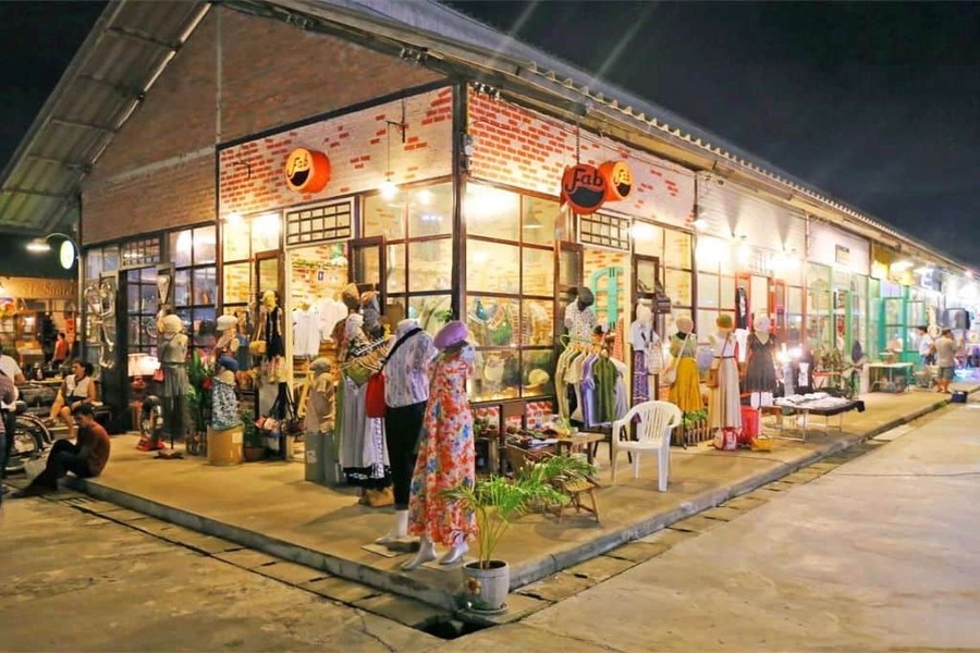 Ambiance nocturne au marché Talad Rot Fai, célèbre pour ses stands rétro, sa nourriture de rue et ses objets vintage