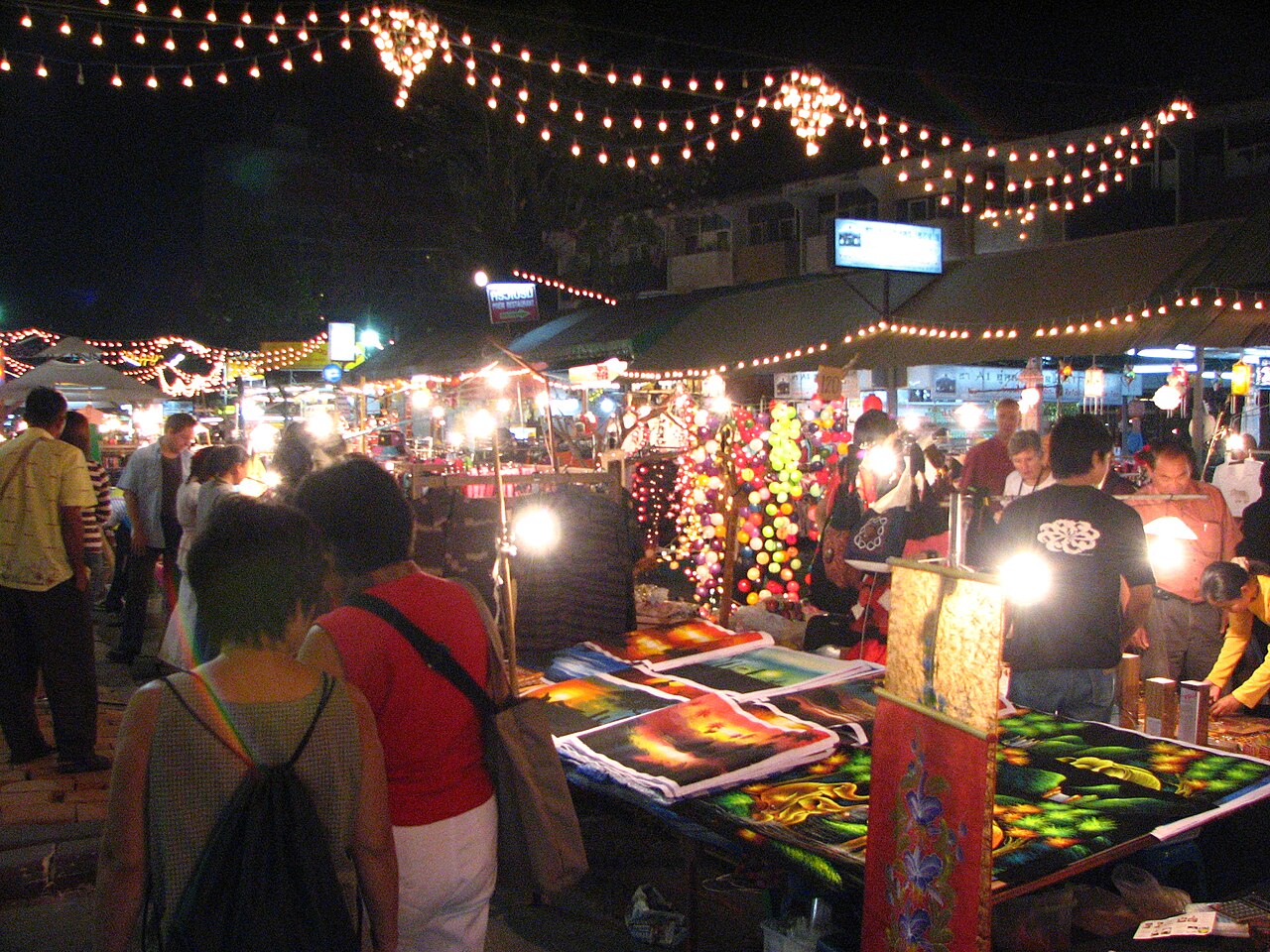 Stands illuminés et promeneurs le soir au bazar de nuit de Chiang Mai