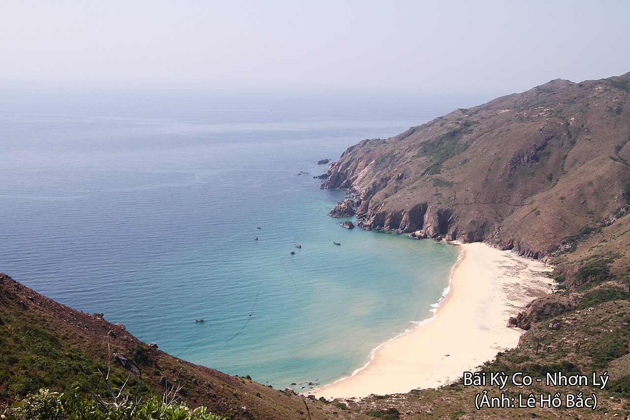 Plage de sable blanc de Kỳ Co au pied des montagnes, mer turquoise, vue depuis la colline