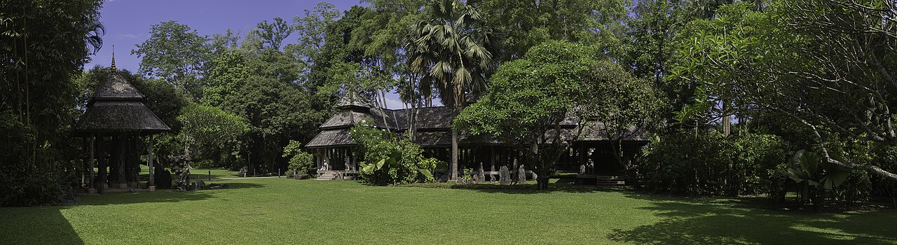 Pelouse, grands arbres et pavillons de bois dans les jardins de Mae Fah Luang