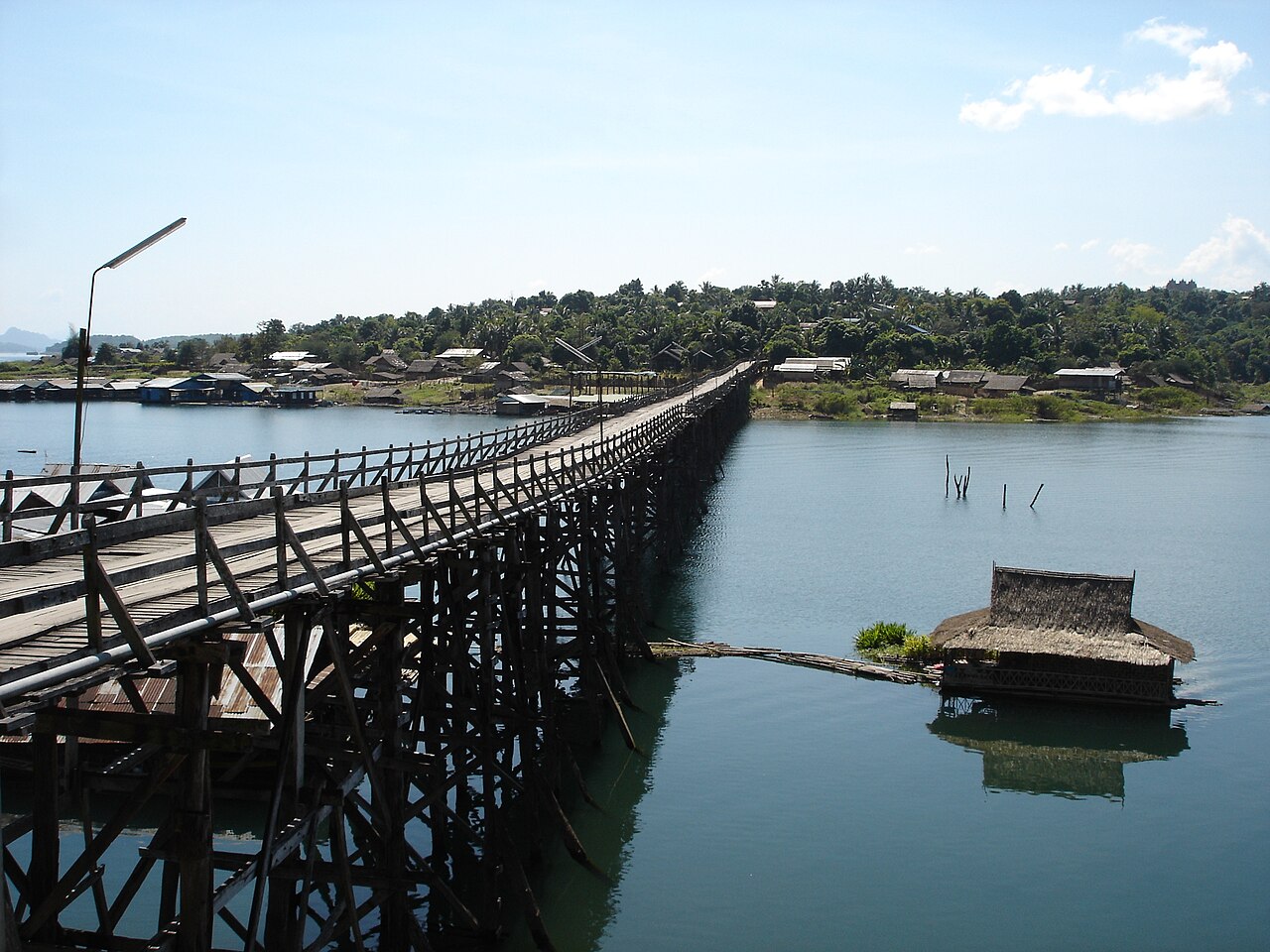 Long pont de bois du pont Mon et maisons flottantes sur le lac de Sangkhla Buri