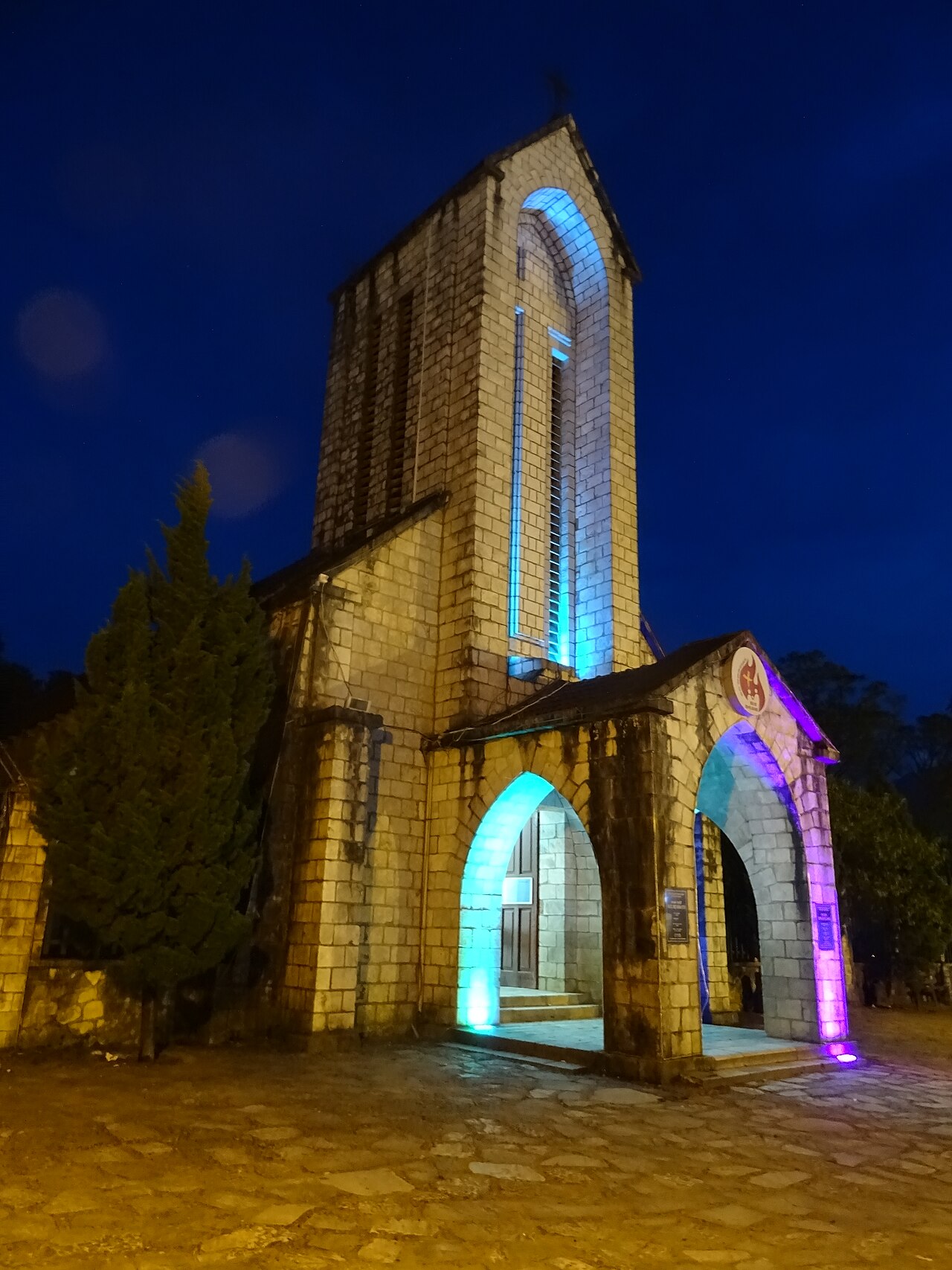 Clocher de l'église de Sa Pa éclairé de lumières colorées la nuit