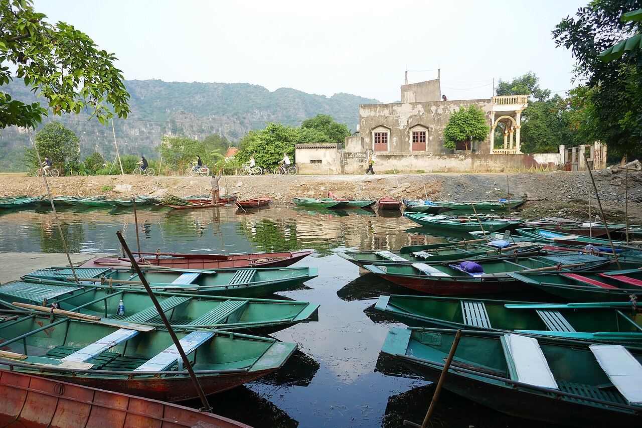 Barques vertes amarrées à l'embarcadère de Tam Cốc