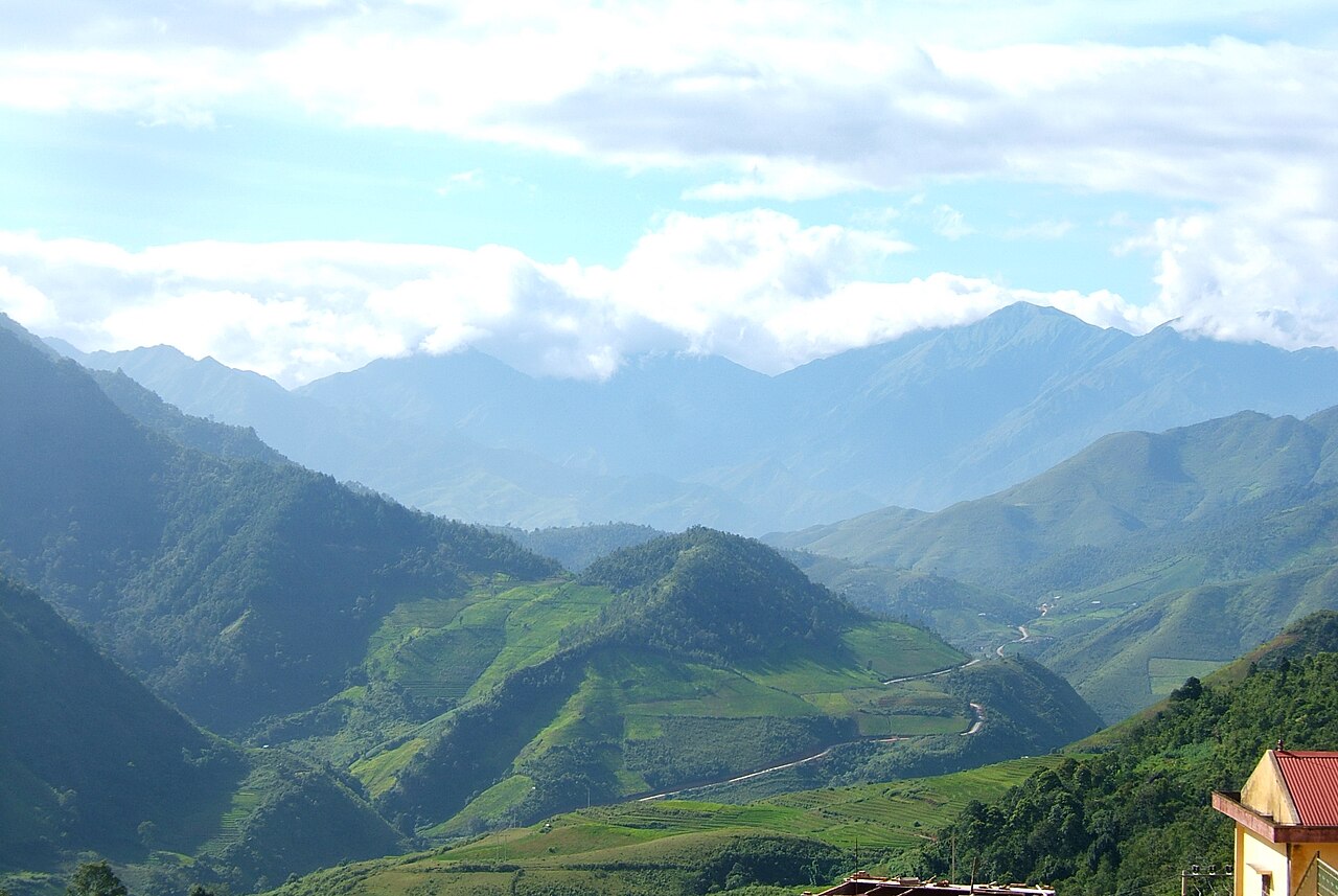 Route de montagne sinueuse et crêtes bleutées dans la région de Trạm Tấu
